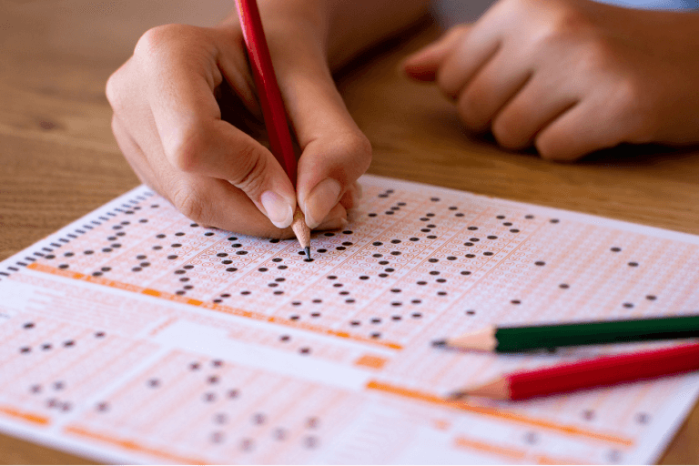 toefl | ielts | pte - hand on paper shading the answers on a scantron sheet.